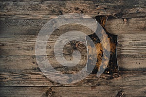 Rustic wooden cutting board on a textured wooden surface in a shabby kitchen setting