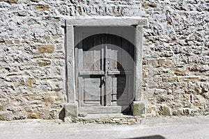 Rustic wooden doors on stone wall