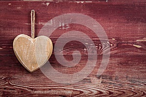 A rustic wooden heart on a red board