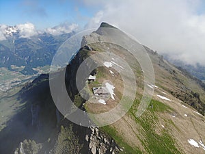 Rustic wooden hut perched atop a mountainous landscape