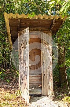 Rustic Wooden Outhouse in Forest
