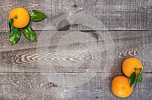 Rustic wooden plank table with fresh picked oranges with stem an