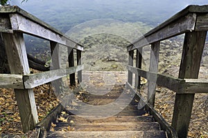 Rustic wooden stairs leading down to small landing at clear fresh water