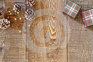 Rustic wooden surface with rustic snowy pine cones, berries and