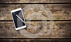 Rustic wooden table with smartphone. View from above