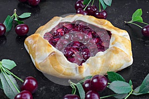 Rustical Sour Cherry Pie on Black Background with a few sour che