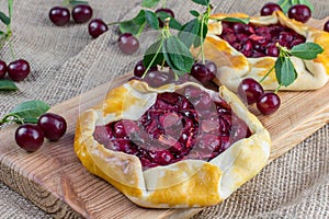 Rustical Sour Cherry Pie on Jute Fabric with a few sour cherries