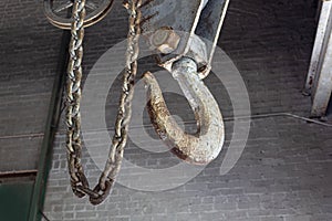 Rusting chain fall hoist hook in an industrial setting
