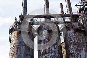 Rusting derelict steel mill blast furnaces with catwalks