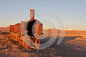Rusting locomotive at sunset