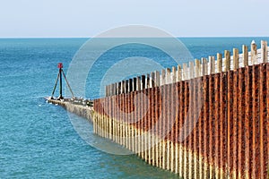 Rusting metal sea defence barrier