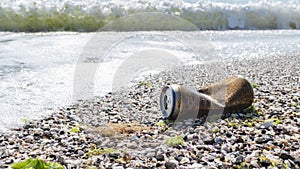 Rusty aluminum can on sea beach discarded sea wave. Garbage pollution of ocean. Metal waste recycling Banner, copy space