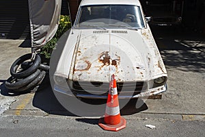 A rusty American muscle classic vintage car in a repair shop in the street of Istanbul