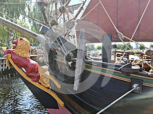 Rusty anchor is anchored between the wooden blocks and the rigging of an old sailing ship