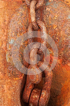 Rusty anchor chain on the background of rusty, salt-eaten metal on board the ship abandoned after the shipwreck.