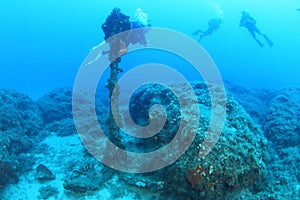 Rusty anchor with divers behind