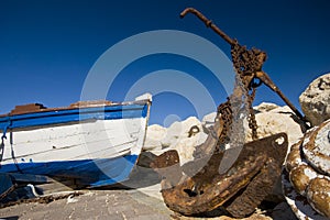 Rusty anchor and an old boat