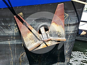 Rusty anchor on the side of a boat