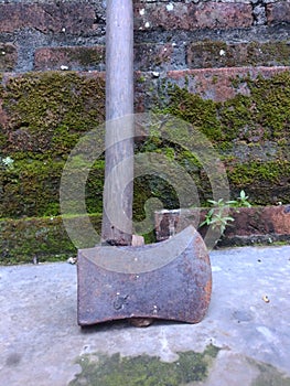 Rusty ax leaning againts the wall