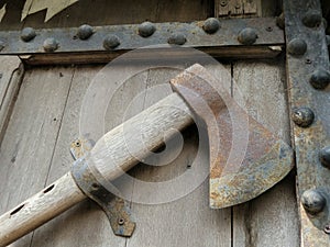 Rusty axe on old wooden door