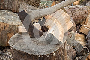 Rusty Axe on a Stump Beside Chunks of Firewood