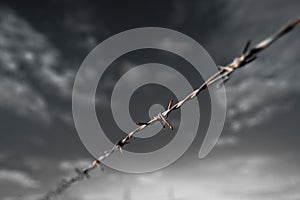 Rusty Barbed wire fence along the boundary line.Black and White Conceptual Image .shallow focus effect