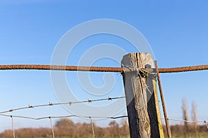 Rusty barbed wire old rough rusted metal posts