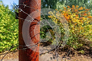 Rusty barbed wire on rusty post in ghost town Pripyat Chornobyl Zone photo
