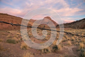 Rusty Barbwire with red rock desert background in Arizona