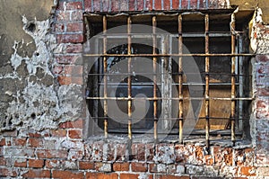 Rusty bars on the window old building ruin, damaged brick wall