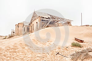 Rusty bathtub and ruins on a dune at Kolmanskop