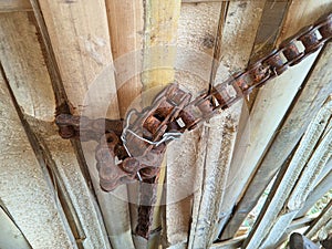 Rusty bicycle chains are used on bamboo wall hinges