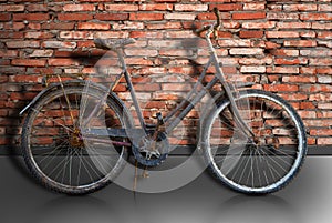 Rusty bike parked by brick wall
