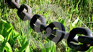 Rusty black heavy cast iron chain. Motion.