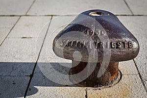 Rusty bollard standing on a stone floor