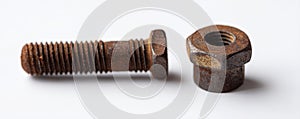 A rusty bolt and nut on a white surface
