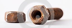A rusty bolt and nut on a white surface