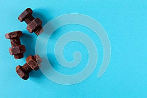 Rusty bolts and nuts made of chocolate isolated on sky blue background