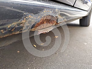 Rusty car undercoat weathered and rotten with rust on car body needs professional car repair service for corrosion and corroded ca photo