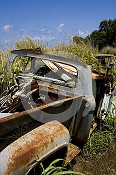 Rusty carwreck in field