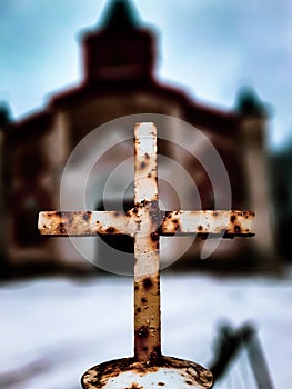 rusty Catholic cross on a blurry background