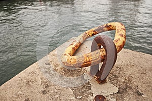 Rusty chain for boat anchor on pier. Closeup photo