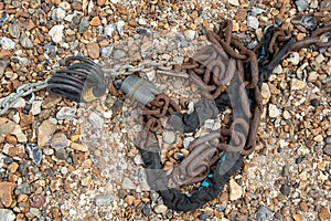 Rusty chain with locker on a gravel surface. Vechicle boat security.