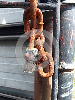 rusty chain with padlock key dangling turnstile fastener accentuates a firmer texture