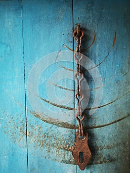 Rusty Chain on Weathered Blue Wooden Door