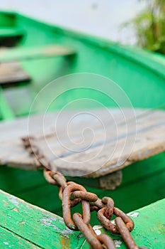 Rusty chain in a wooden boat by the lake