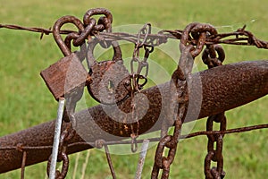 Rusty padlocks fence and chains left on a gate