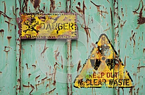 Rusty,damaged and leaking nuclear waste container with radiation warning sign. Dangers of nuclear energy and atomic power concept.