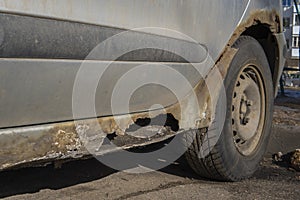 Rusty and dirty car door damaged by corrosion. Hole in the door car. Negligent attitude to the car. Lack of anticorrosion