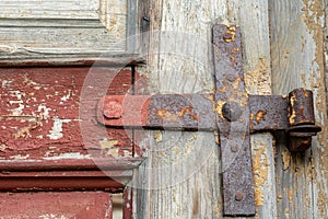rusty door hinges close-up on an old wooden door. Forged metal products made in the last century
